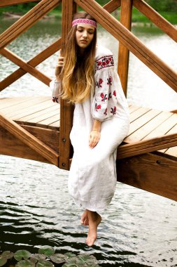 Güzel ince Ukrayna dili nakış köprüde su üzerine oturur.