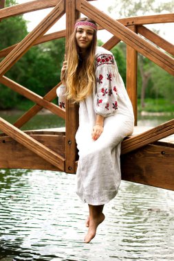 Güzel ince Ukrayna dili nakış köprüde su üzerine oturur.