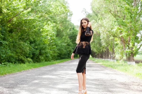 古いアスファルトでスタイリッシュな黒い服を着た美しい細身のウクライナの女性 — ストック写真
