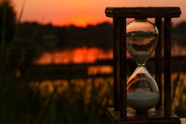 Kırmızı günbatımı çerçevede bir kum saati geri sayımı