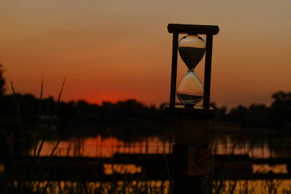 砂時計カウント ダウン時間赤い夕日背景 — ストック写真