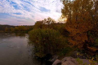 nehir kıyısında kayalık sonbahar ağaçlar