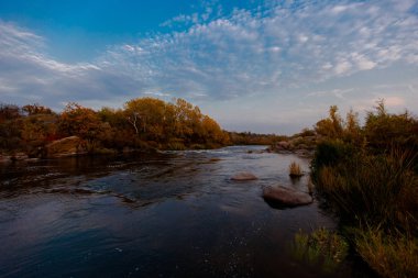 bulutlu gökyüzü altında hızlı Nehri'nin karanlık su pleso