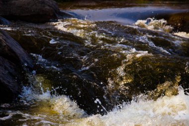 taş rapids sıçraması ve köpük ile yakın çekim çevresinde güçlü su akışı gider