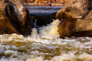 taş rapids sıçraması ve köpük ile yakın çekim çevresinde güçlü su akışı gider