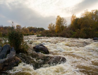 renkler ve renk tonlarının akıntıdan parlak bir sonbahar gününde etrafında dağ nehir akışının oyunu