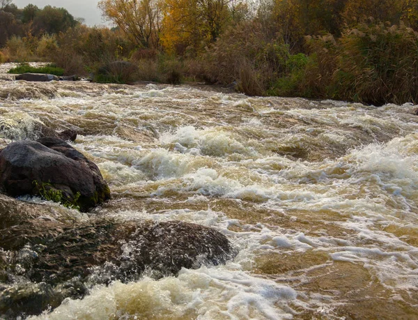 renkler ve renk tonlarının akıntıdan parlak bir sonbahar gününde etrafında dağ nehir akışının oyunu