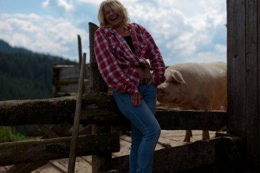 Kız domuzla eğleniyor.