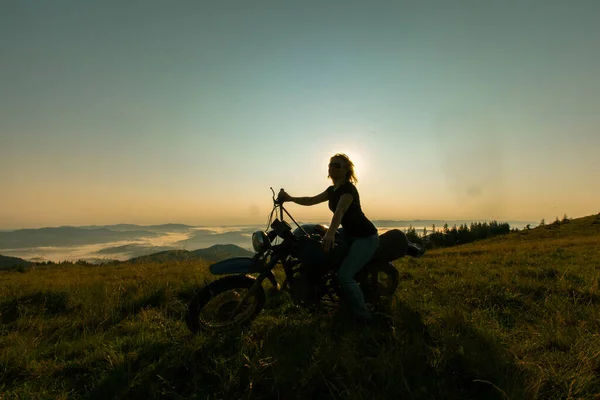 山の中のバイクの上の女の子は夜明けの旅行で休むのをやめた — ストック写真