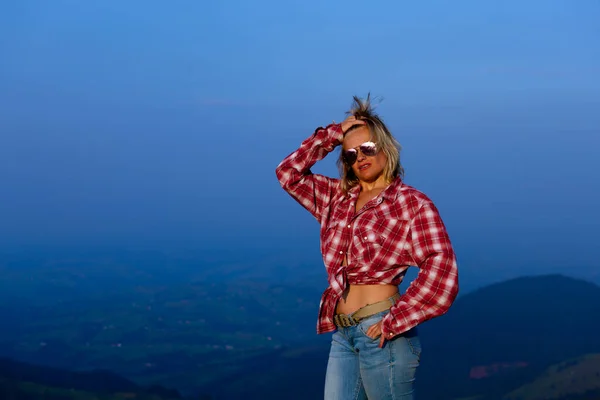 青い霞の中の山を背景にポーズをとった赤い縞のシャツの少女 — ストック写真