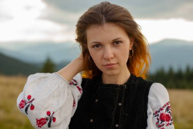 Bulutlu bir yaz gününde Karpatlar 'da nakış işlemiş bir kızın portresi.