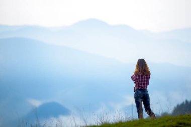 Kız turist dağlarda gün batımında Karpatların tepesinde güneş sisi