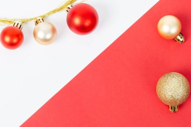 Kırmızı ve beyaz arka plan, kırmızı ve altın renkli süslemeler. Kırmızı ve beyaz arka plan, altın ve kırmızı süslemelerin karşıtıdır, neşeli ve neşeli bir atmosfer yaratır.