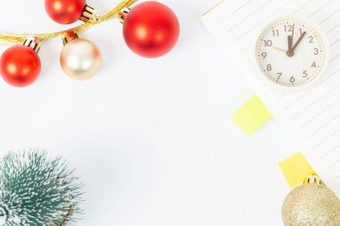 Noel ağacı ve saati olan beyaz bir arka plan. Ağaç kırmızı ve altın toplarla süslenmiş.