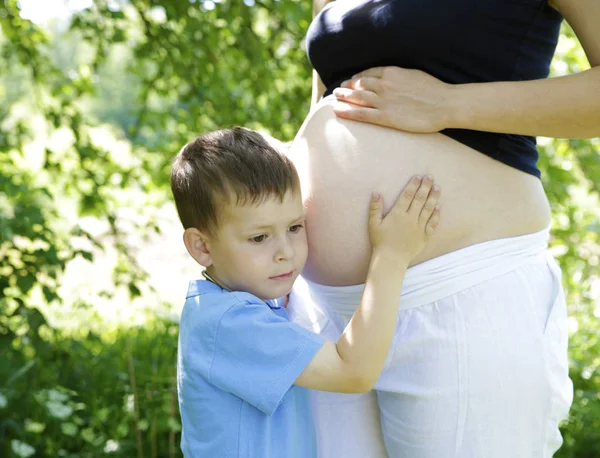 hamile kız bahçede oğlu ile istirahat ediyor. fotoğraf-stok fotoğraf 