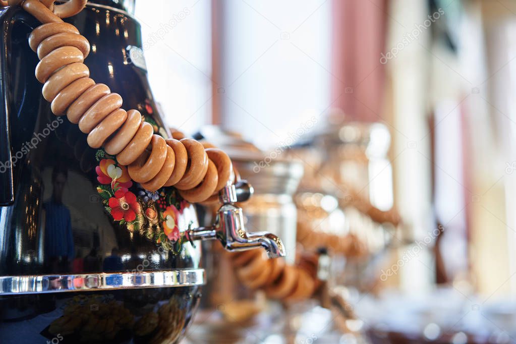 Russian traditional painted samovar with delicious herbal tea and donuts