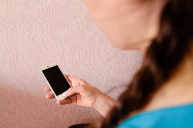 mavi tişört bir kızla elinde beyaz gadget smartphone