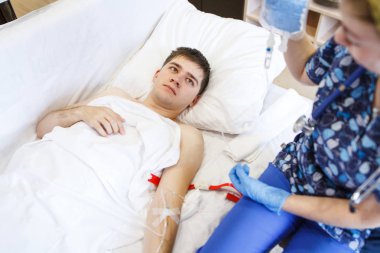 Hemşire hasta bir damar yoluyla hastaya enjekte eder. Enjeksiyon hastanın baş yukarıda tutan