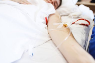 Hemşire hasta bir damar yoluyla hastaya enjekte eder. Enjeksiyon hastanın baş yukarıda tutan