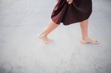 Güzel bir kız ve kıyı günbatımı karşı yürüyor