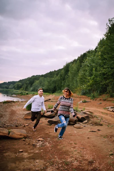 Giovane coppia divertirsi e correre lungo il fiume — Foto Stock