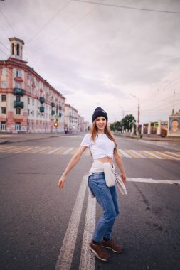 Yolun ortasında poz veren kız. Şık giysi ve şapka kız.