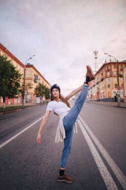 Yolun ortasında poz veren kız. Şık giysi ve şapka kız.