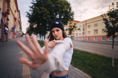 Kız bir ret gösteriyor. Şık giysi ve şapka kız.