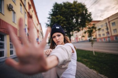 Kız bir ret gösteriyor. Şık giysi ve şapka kız.