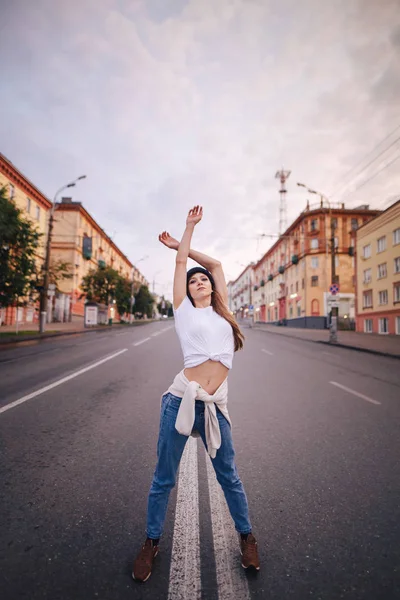 Yolun ortasında poz veren kız. Şık giysi ve şapka kız.