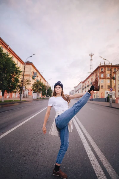 Yolun ortasında poz veren kız. Şık giysi ve şapka kız.