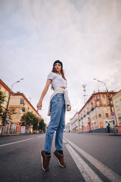 Yolun ortasında poz veren kız. Şık giysi ve şapka kız.