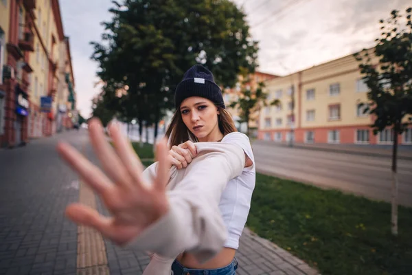 Kız bir ret gösteriyor. Şık giysi ve şapka kız.