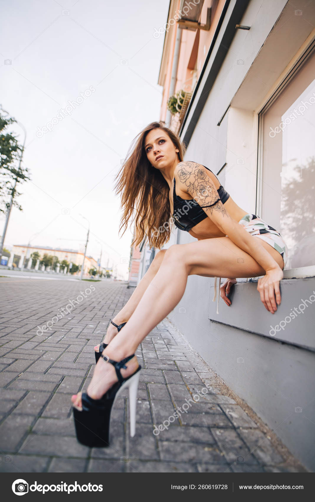 Girl in heels posing among the streets of the city. Girl in a black top short shorts. Photo by ©mushegovdima 260619728