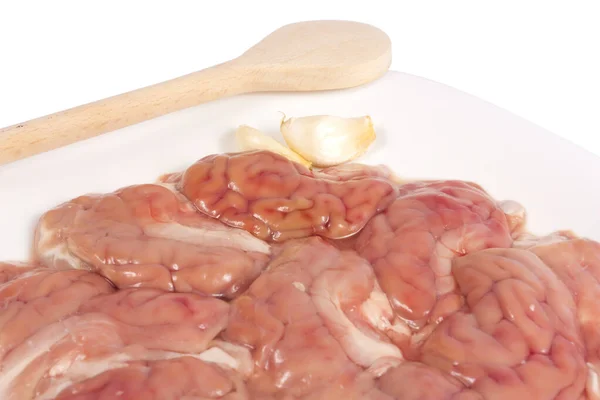 pişirme ve sarımsak bir tahta kaşıkla izole kırpma yolu ile beyaz zemin üzerinde bir plaka üzerinde ham beyin