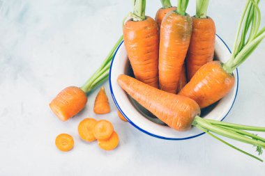 Beyaz kase, gri taş arka planda taze havuç