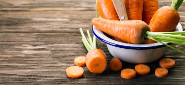 Beyaz emaye plaka, ahşap arka plan, taze sebze havuç