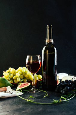 Kırmızı şarap üzüm incir ve siyah arka plan üzerine peynir