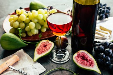 Kırmızı şarap üzüm incir ve siyah arka plan üzerine peynir