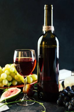 Kırmızı şarap üzüm incir ve siyah arka plan üzerine peynir