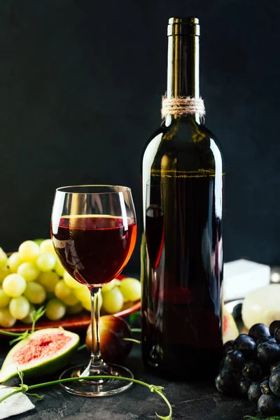Kırmızı şarap üzüm incir ve siyah arka plan üzerine peynir