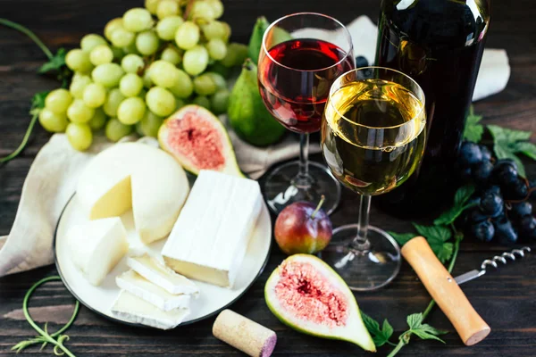 Kırmızı şarap üzüm incir ve siyah arka plan üzerine peynir