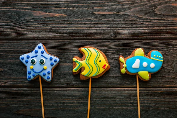 Gingerbread Gingerbread on a stick on a wooden background Aircraft Star Fish Multicolored