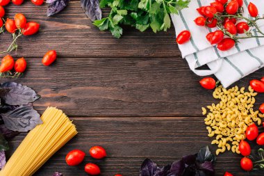 Spagetti yemek çerçeve domates kiraz fesleğen ve ahşap zemin üzerine kereviz