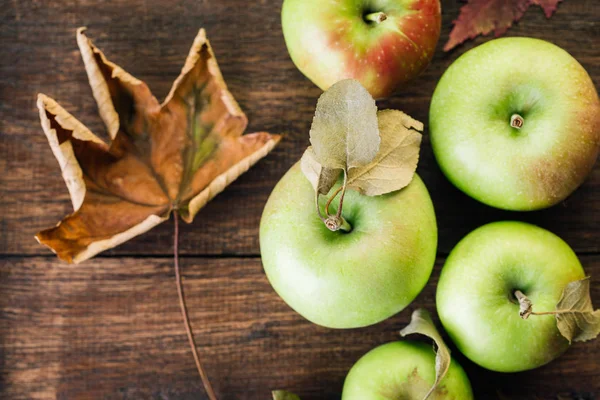 Green Apples and Fallen Leaves on Wooden Background Autumn Still Life