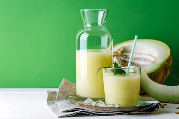 smoothies melon on a green background, glass bottle and slice next to, summer drink, cocktail