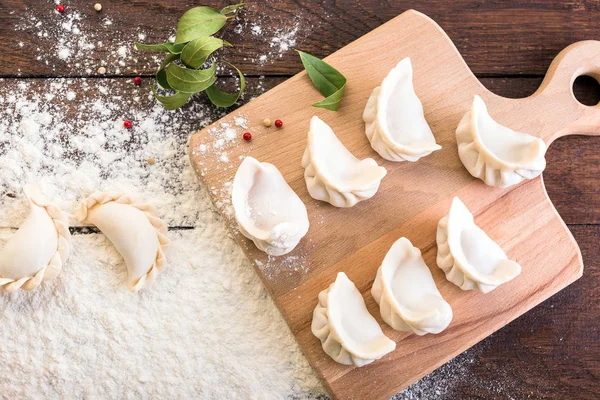 Mantı yemek bir yönetim kurulu ve ahşap arka plan, Ulusal Rus yemekleri, vareniki