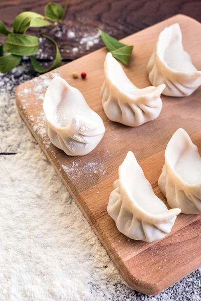 Mantı yemek bir yönetim kurulu ve ahşap arka plan, Ulusal Rus yemekleri, vareniki