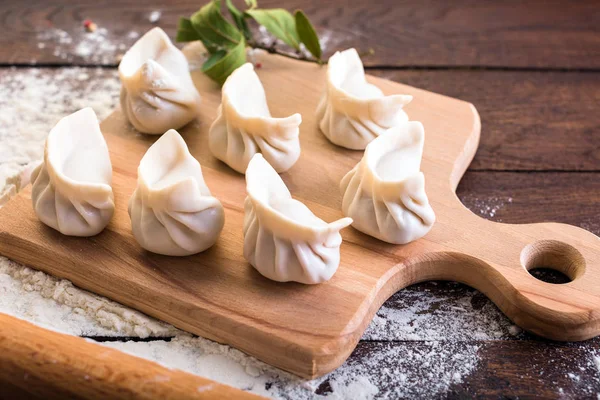 Mantı yemek bir yönetim kurulu ve ahşap arka plan, Ulusal Rus yemekleri, vareniki