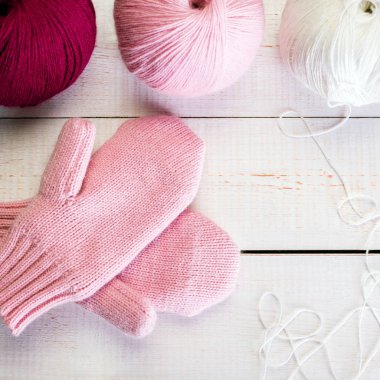 Kış, beyaz eski ahşap zemin, bir skein iplik örme pembe mittens seviyorum